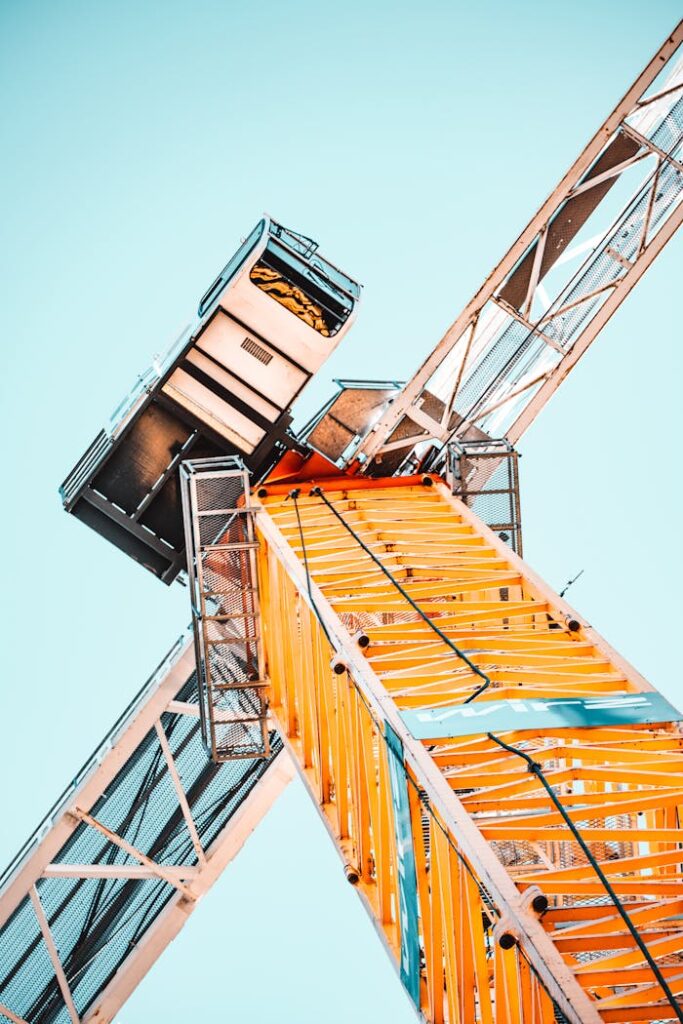 pexels photo 2068478 A striking low angle shot of a vibrant yellow tower crane against a clear sky, showcasing industrial power.
