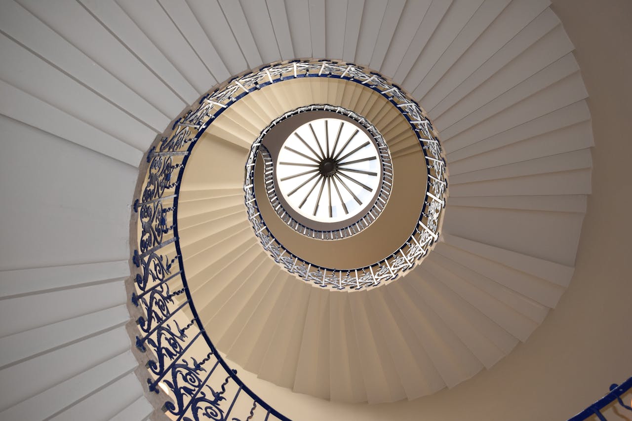 gallery-6 A captivating view up a spiral staircase with intricate railing design.